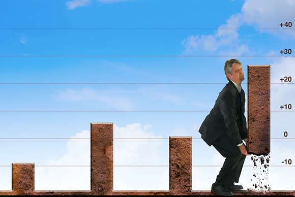 Picture of a man in a business suit lifting the most recent bar graph on a chart to demonstrate even more stock price .growth