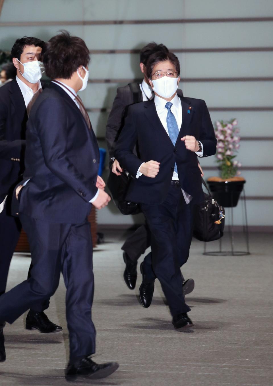 Japanese Chief Cabinet Secretary Katsunobu Kato (R) rushes into the prime minister official residence after a strong earthquake hit northeastern JapanEPA