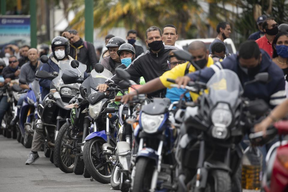 Motorcyclists wearing masks amid the new coronavirus pandemic wait their turn to fill up at a gas station in Caracas, Venezuela, Tuesday, Sept 8, 2020. Gasoline shortages have returned to Venezuela, sparking mile-long lines in the capital as international concerns mounted that Iran yet again may be trying to come to the South American nation's rescue. (AP Photo/Ariana Cubillos)