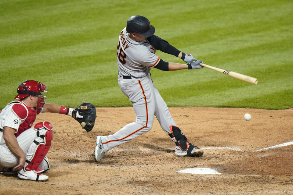 San Francisco Giants' Buster Posey, right, hits a single off Philadelphia Phillies pitcher Connor Brogdon during the eighth inning of a baseball game, Tuesday, April 20, 2021, in Philadelphia. (AP Photo/Matt Slocum)