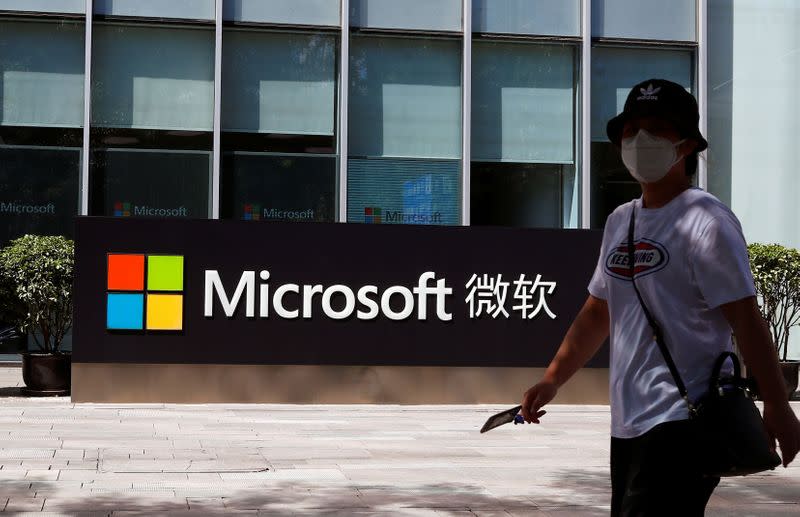 A person walks past a Microsoft logo at the Microsoft office in Beijing