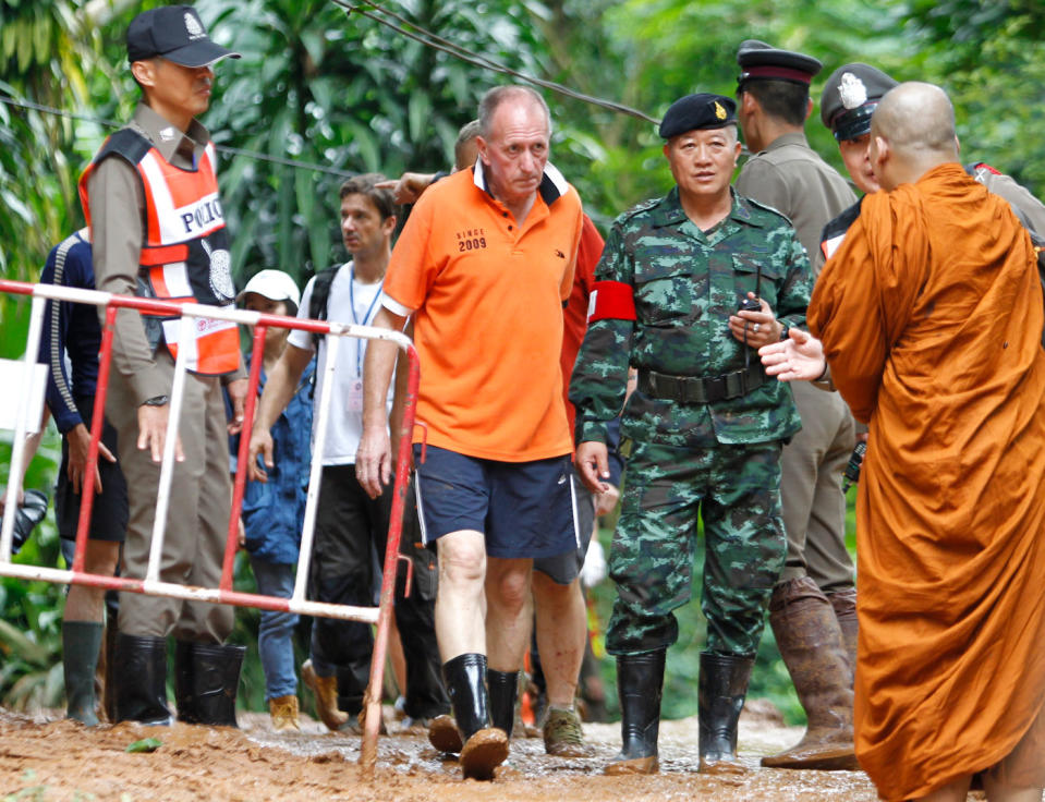Vern Unsworth walks next to a Thai soldier and policemen during the rescue operation at the Tham Luang cave. Source: AAP