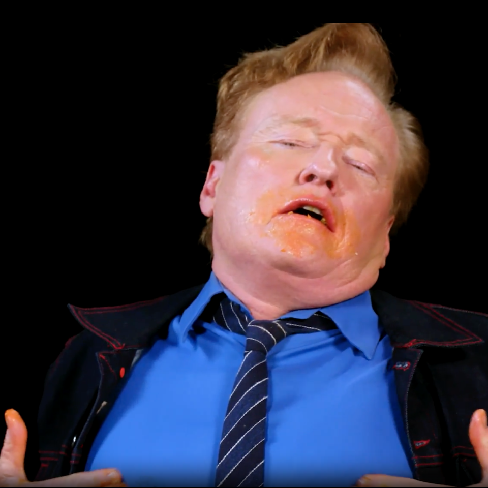 Conan with a humorous expression and an orange substance on his face and fingers