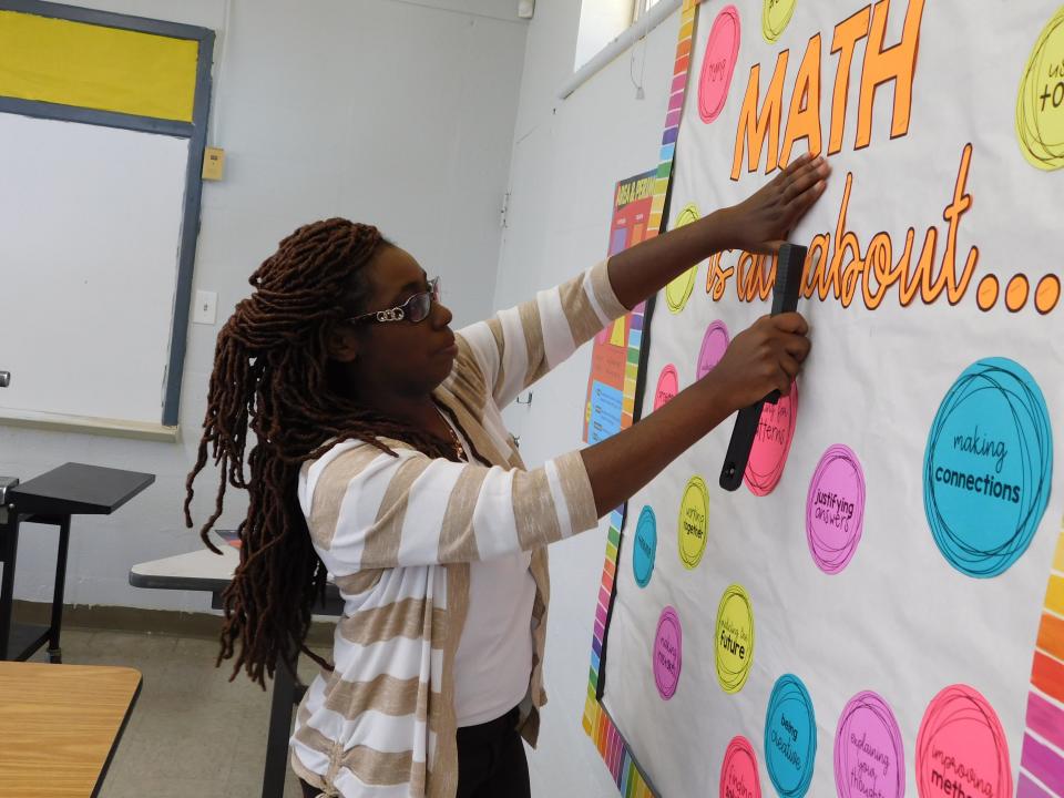 Fifth-grade teacher Crystal Green prepares a bulletin board for her homeroom class.