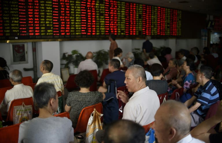 Investors monitor screens showing stock market movements at a brokerage house in Shanghai on July 29, 2015