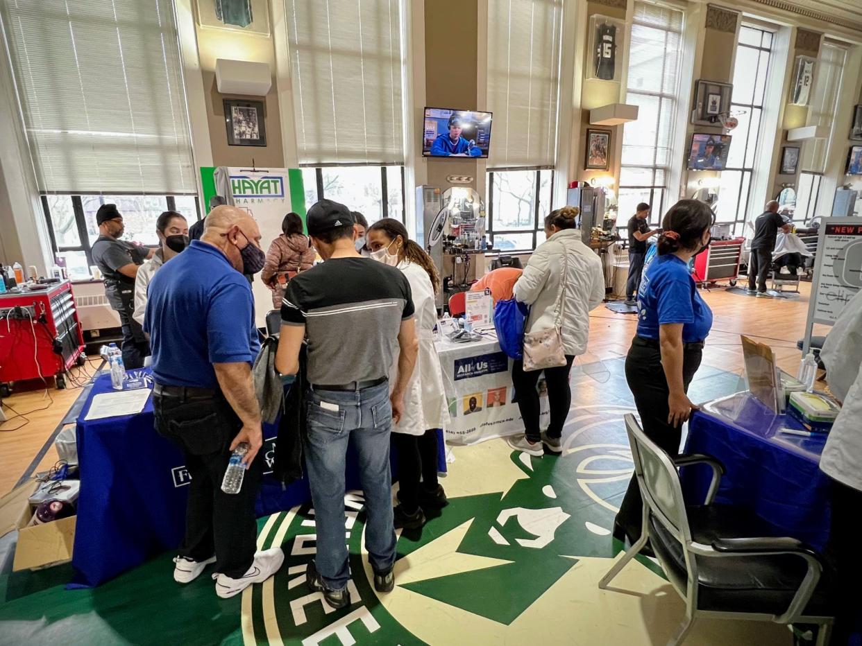 Gee's Clippers is hosting its second hair, skin and nail screening event, sponsored by Froedtert and the Medical College of Wisconsin health system. In the center, Dr. Shola Akinshemoyin Vaughn speaks with patients.