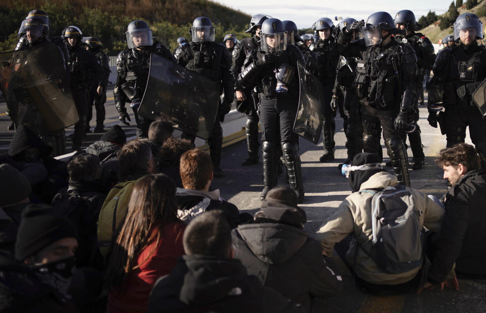 French police officers cordon off the access as pro-Catalan independence demonstrators try to block a major highway border pass near La Jonquera between Spain and France, Monday, Nov. 11, 2019. Protesters following a call to action by a secretive pro-Catalan independence group have closed off both sides of the AP7 highway at the major transportation hub of La Jonquera between France and Spain. (AP Photo/Felipe Dana)