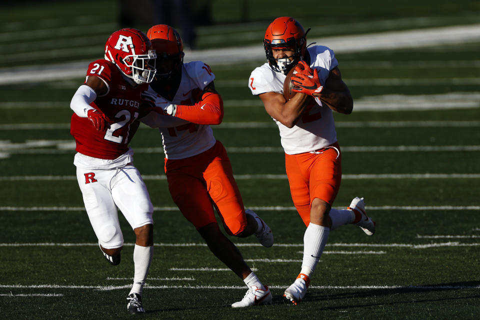 Illinois running back Chase Brown (2) rushes past Rutgers defensive back Tre Avery (21) during the second half of an NCAA college football game, Saturday, Nov. 14, 2020, in Piscataway, N.J. Illinois won 23 - 20. (AP Photo/Adam Hunger)