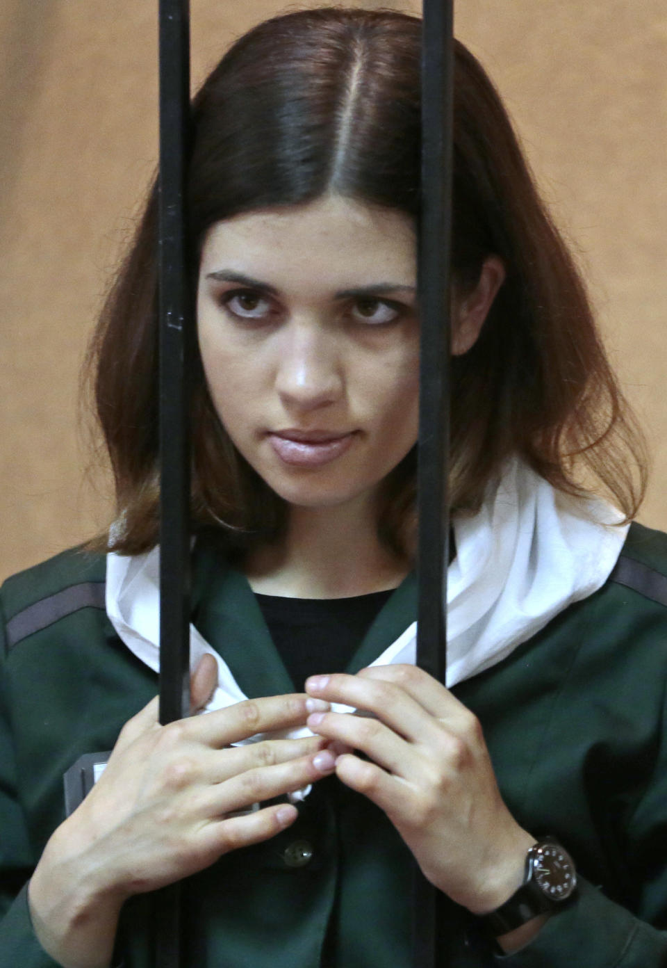 In this Friday, April 26, 2013 file photo, Nadezhda Tolokonnikova, a member of the feminist punk band Pussy Riot, listens from behind bars at a district court in Zubova Polyana, 440 kilometers (273 miles) southeast of Moscow, in Russia's province of Mordovia. (AP Photo/Mikhail Metzel, file)