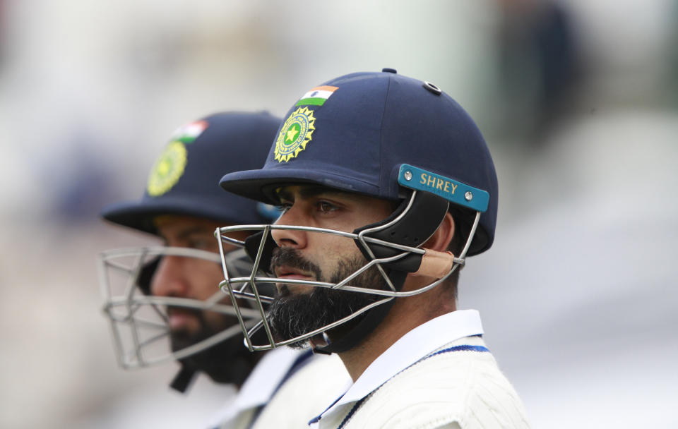 India's captain Virat Kohli, right, and batting partner Cheteshwar Pujara wait to walk into the field after the lunch break during the second day of the World Test Championship final cricket match between New Zealand and India, at the Rose Bowl in Southampton, England, Saturday, June 19, 2021. (AP Photo/Ian Walton)