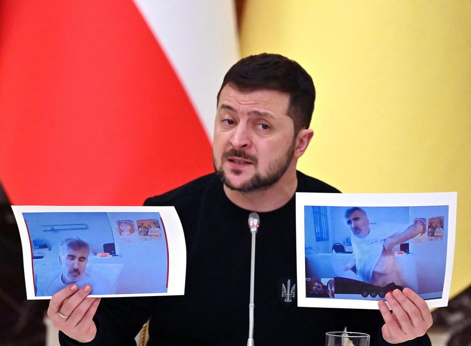 Ukrainian President Volodymyr Zelensky holds images of former Georgian President Mikheil Saakashvili taken in prison, during a press conference in Kyiv on Feb. 1, 2023.<span class="copyright">Sergei Supinsky—AFP/Getty Images</span>