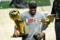 Milwaukee Bucks forward Giannis Antetokounmpo smiles while holding the NBA Championship trophy, left, and Most Valuable Player trophy after defeating the Phoenix Suns in Game 6 of basketball's NBA Finals in Milwaukee, Tuesday, July 20, 2021. The Bucks won 105-98. (AP Photo/Paul Sancya)