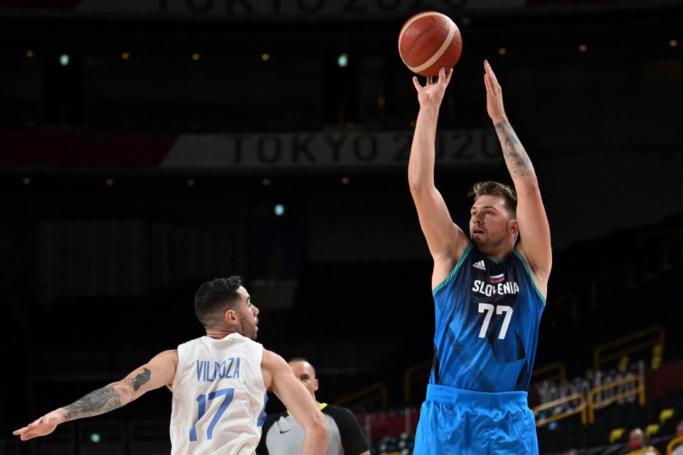 Slovenia's Luka Doncic (R) takes a shot past Argentina's Luca Vildoza the men's preliminary round group C basketball match between Argentina and Slovenia during the Tokyo 2020 Olympic Games at the Saitama Super Arena in Saitama on July 26, 2021. (Photo by Aris MESSINIS / AFP) (Photo by ARIS MESSINIS/AFP via Getty Images)