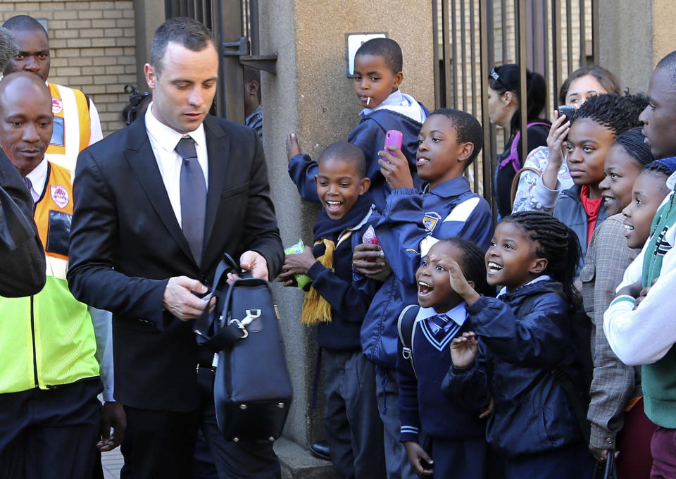 Children react as Oscar Pistorius, left, leaves the high court in Pretoria, South Africa, Monday, May 12, 2014. Pistorius is charged with murder for the shooting death of his girlfriend, Reeva Steenkamp, on Valentines Day in 2013. (AP Photo/Themba Hadebe)
