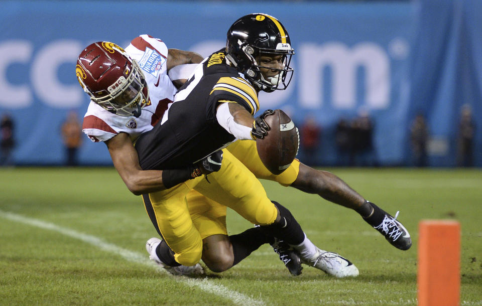 Iowa wide receiver Brandon Smith, right, reaches forward as he goes out of bounds as he is tackled by Southern California cornerback Olaijah Griffin during the first half of the Holiday Bowl NCAA college football game Friday, Dec. 27, 2019, in San Diego. (AP Photo/Orlando Ramirez)