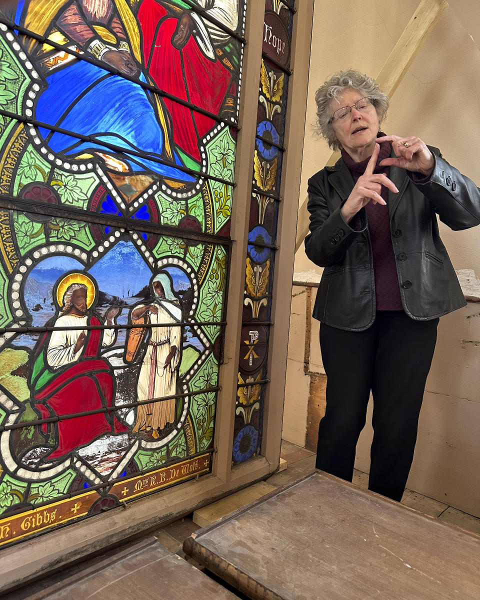 Holy Cross professor and stained-glass expert Virginia Raguin speaks to a group of middle school students, Monday, May 1, 2023, while standing near a nearly 150-year-old stained-glass window that depicts Christ speaking to a Samaritan woman, in the now-closed St. Mark's Episcopal church, in Warren, R.I. The nearly 150-year-old stained-glass window from the Rhode Island church that depicts Christ and three New Testament women with dark skin has stirred up questions about race and the place of women in both biblical and 19th century society. (AP Photo/Mark Pratt)