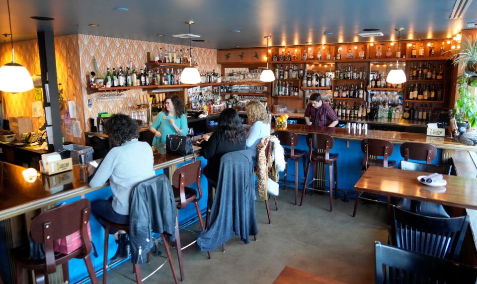 Customers enjoy food and drinks at the bar area as owner Melissa Buchholz (left) and bartender Aaron Schuster work behind the bar at Odd Duck restaurant on 939 S. 2nd St. in Milwaukee on Wednesday, Dec. 20, 2023. The restaurant has been elected as one of the USA TODAY Restaurants of the Year 2024.