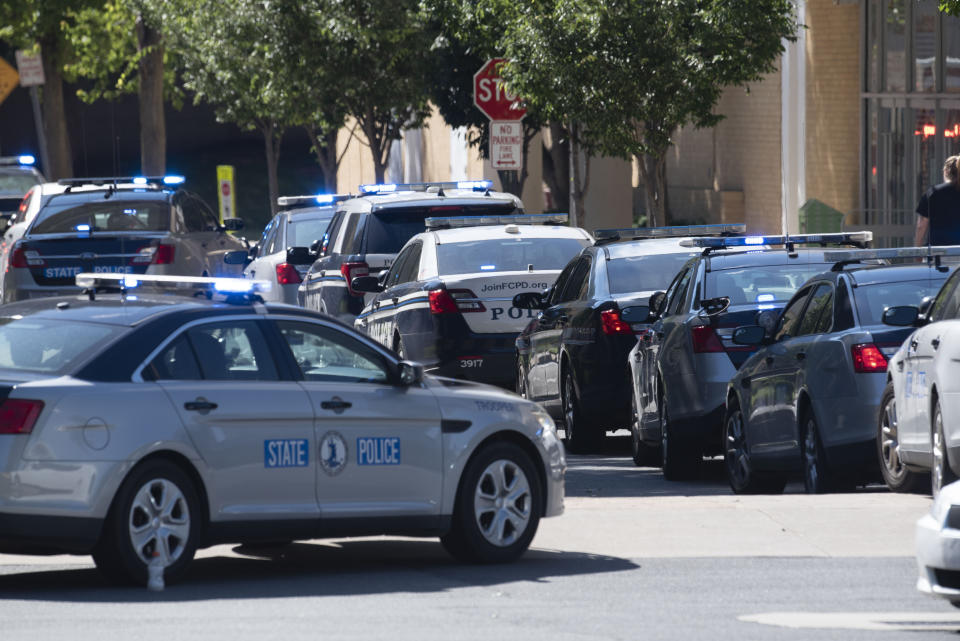 Virginia State Police and Fairfax County police vehicles are parked outside the Bloomingdale's store following a shooting inside the Tysons Corner Center mall, in Tysons Corner, Va., Saturday, June 18, 2022. (AP Photo/Cliff Owen)