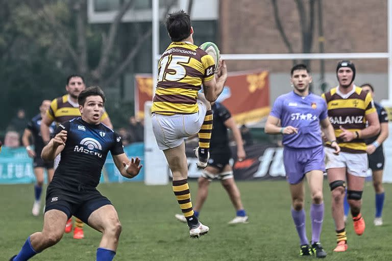 Justo Piccardo mira cómo Nicolás Spinelli desactiva una "bomba" aérea; el de Belgrano jugó como fullback y eso desplazó a Juan Landó a la posición de apertura, vacante por una lesión de Juan Aparicio.