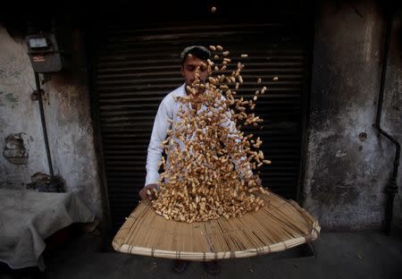 A man sorts through peanuts for sale at a shop in Peshawar, Pakistan January 5, 2017. REUTERS/Fayaz Aziz/Files