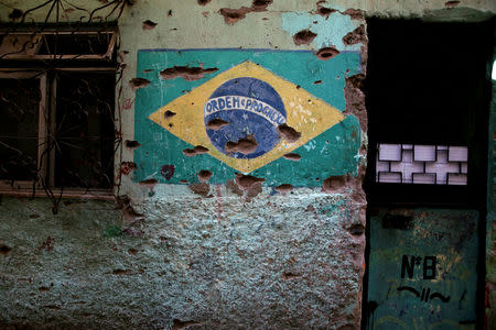 A mural of the Brazilian flag is damaged by bullet holes in Jacarezinho slum in Rio de Janeiro, Brazil, January 10, 2018. REUTERS/Pilar Olivares