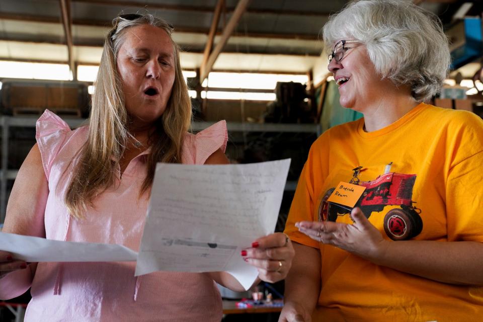 Lori Galanti, of Milan and Brenda Reum look over family history together at the 115th annual Rendel Family Reunion in Milan on July 30, 2023.
