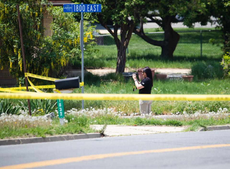 A crime scene investigator photographs the scene of what police say is a triple homicide in Layton on Friday, May 19, 2023. | Ryan Sun, Deseret News