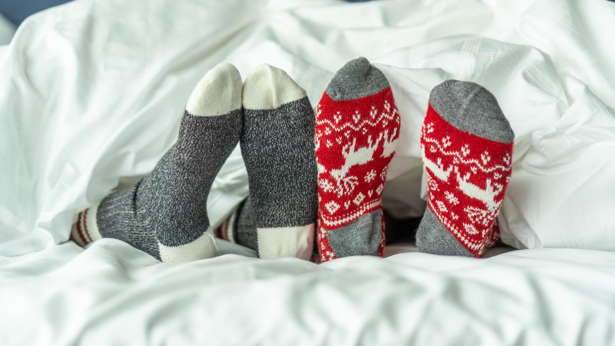 Christmas socks of couple in bed