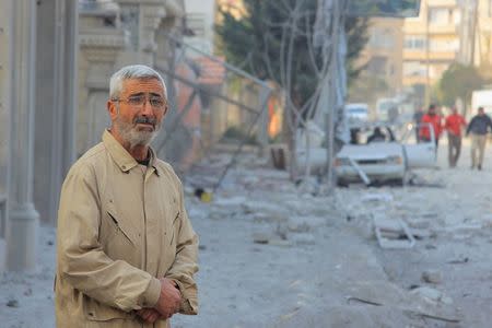 A man inspects a damaged site hit by what activists said were airstrikes carried out by the Russian air force in Idlib city, Syria December 20, 2015. REUTERS/Ammar Abdullah