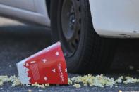 Una caja de palomitas de maíz permanecía tirada en el suelo del parking del cine de Aurora (Colorado) donde se registró el tiroteo mortal. Al menos 12 personas murieron y 59 resultaron heridas este viernes en un tiroteo durante el estreno del último film de Batman en un cine de Colorado (centro de Estados Unidos), lo que provocó la suspensión de la campaña electoral y un decreto de seis días de duelo. (AFP/GETTY IMAGES | thomas cooper)