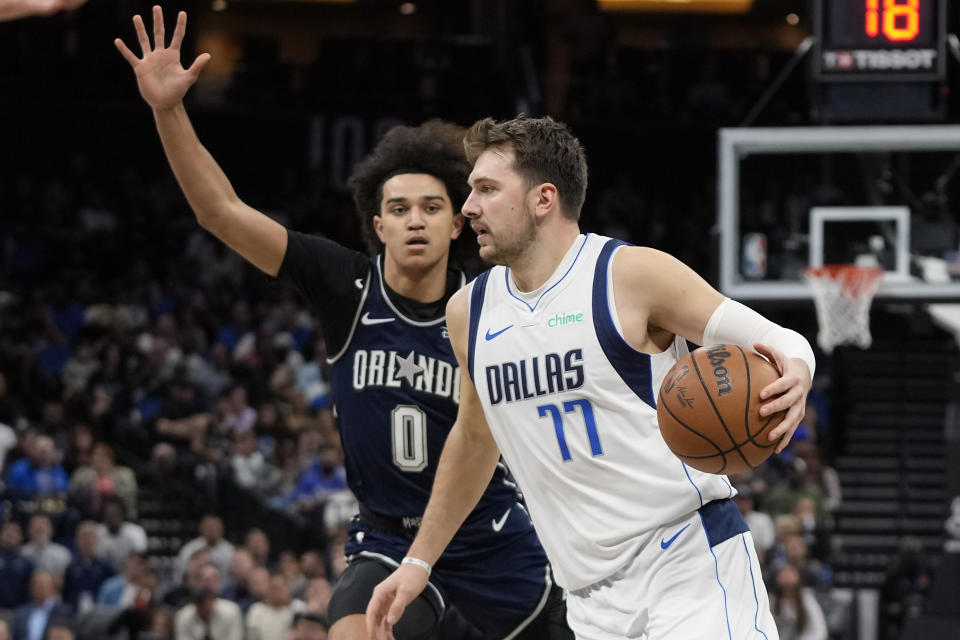 Dallas Mavericks' Luka Doncic (77) makes a move to get past Orlando Magic's Anthony Black (0) during the first half of an NBA basketball game, Monday, Nov. 6, 2023, in Orlando, Fla. (AP Photo/John Raoux)