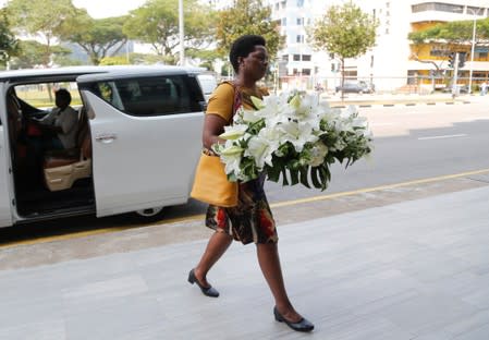 A visitor arrives with a wreath at funeral parlour Singapore Casket, where the body of late former Zimbabwe's President Robert Mugabe is being held in Singapore