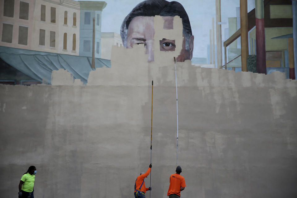 A crew from Mural Arts paints over the Frank Rizzo mural on 9th Street in Philadelphia, Pa. on June 7, 2020. (David Maialetti/The Philadelphia Inquirer via AP)