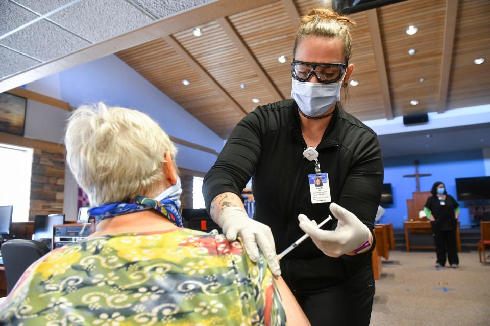 RN Kristi Bryant administers the Moderna COVID-19 vaccine during a CentraCare mobile strike team clinic Wednesday, Feb. 10, 2021, at the Salvation Army center in St. Cloud.