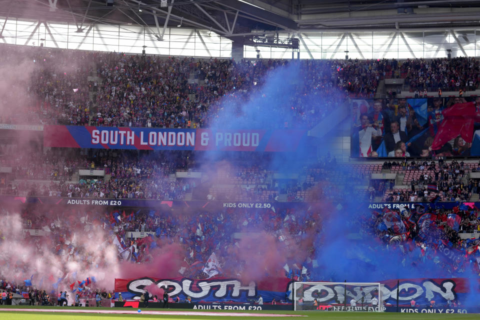 Crystal Palace fans release smoke bombs and wave flags before the start of the English FA Cup semifinal soccer match between Chelsea and Crystal Palace at Wembley stadium in London, Sunday, April 17, 2022. (AP Photo/Kirsty Wigglesworth)