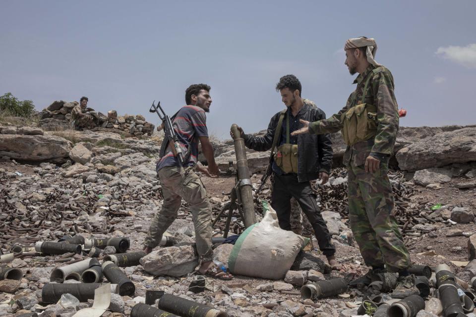 FILE - In this Aug. 5, 2019, file photo, fighters from a militia known as the Security Belt, that is funded and armed by the United Arab Emirates, discuss launching a mortar towards Houthi rebels, in an area called Moreys, on the frontline in Yemen's Dhale province. Fighting between their allies in southern Yemen has opened a gaping wound in the Saudi Arabia and the United Arab Emirates’ coalition fighting the country’s rebels. If they can’t fix it, it threatens to further fragment the country into smaller warring pieces. (AP Photo/Nariman El-Mofty, File)
