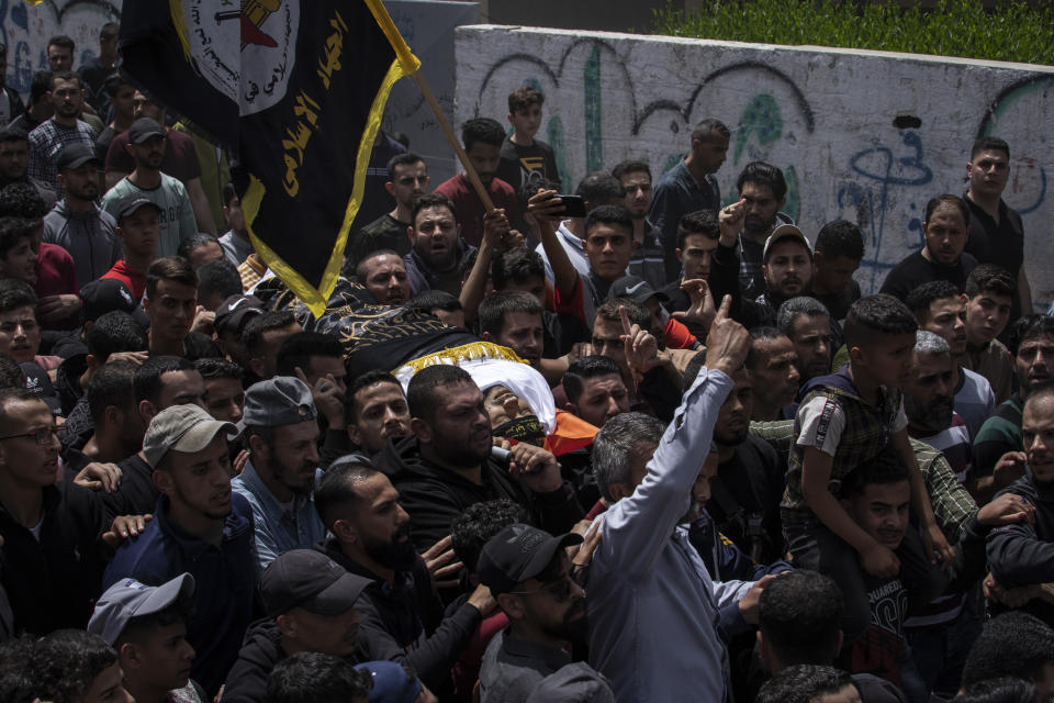 Palestinian mourners carry the body of Alian Abu Wadi, a member of Islamic Jihad militant group, draped in the militant group's flag, during his funeral in Jabalia, northern Gaza Strip, Friday, May 12, 2023. Najjar was killed on Thursday by an Israeli airstrike. Palestinian militants fired rockets toward Jerusalem on Friday, further escalating the most violent confrontation in months between Israel and militants in the Gaza Strip despite efforts to broker a cease-fire. (AP Photo/Fatima Shbair)