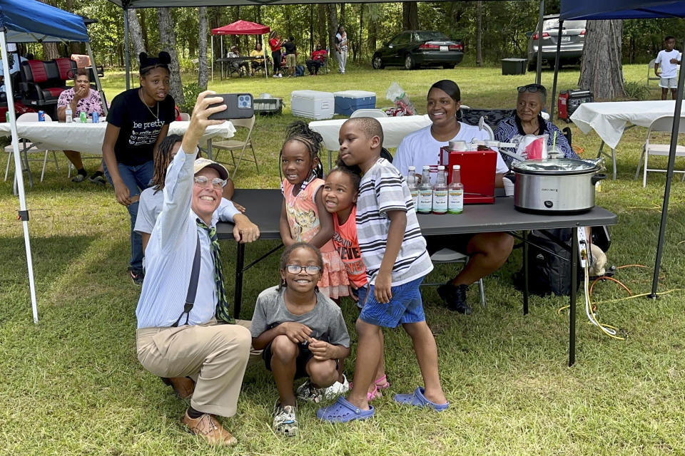 South Carolina state Sen. Mike Fanning, D-Great Falls, poses for a selfie with several young constituents as he travels across his district on Saturday, Aug. 5, 2023, in Blair, S.C. In an increasingly Republican state, Fanning hopes the personal touch can help him keep his seat. (AP Photo/Jeffrey Collins)