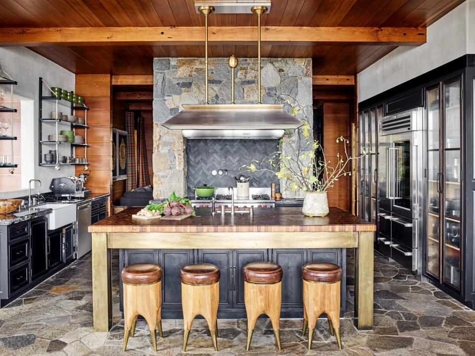 Blackman Cruz barstools line the kitchen island. Custom brass island base and floating shelves by One Off Furniture; billiard light pendant by Urban Archaeology; backsplash and sink fittings by Waterworks; Sub-Zero and Wolf appliances.