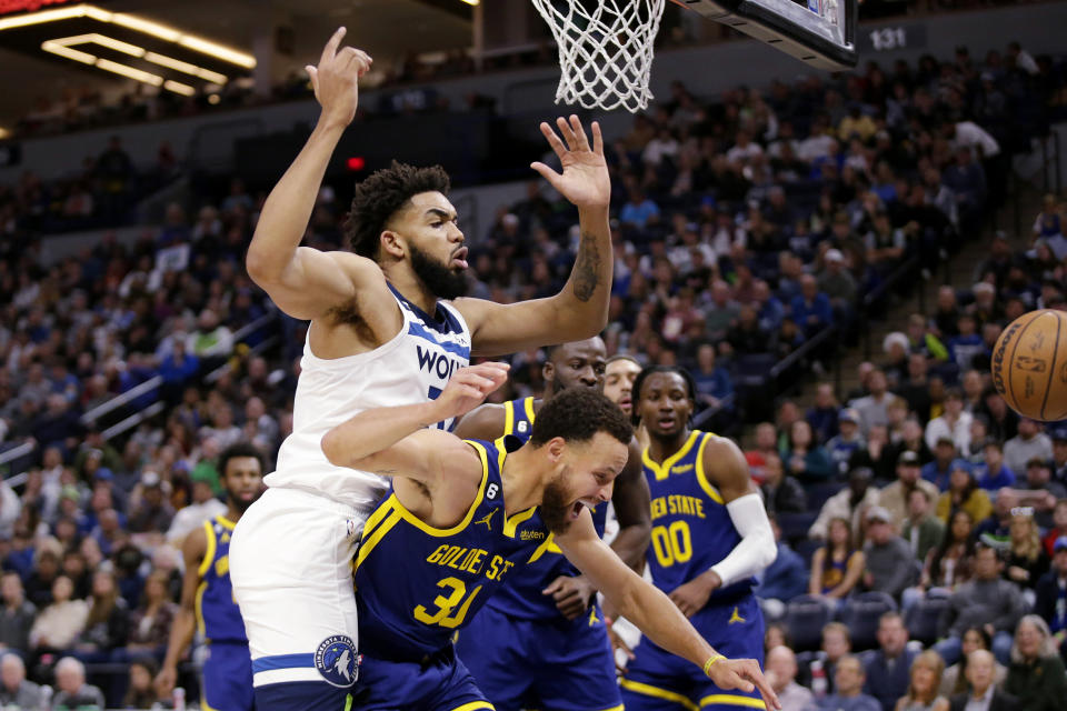 Golden State Warriors guard Stephen Curry (30) and Minnesota Timberwolves center Karl-Anthony Towns (32) collide during the second quarter of an NBA basketball game Sunday, Nov. 27, 2022, in Minneapolis. (AP Photo/Andy Clayton-King)