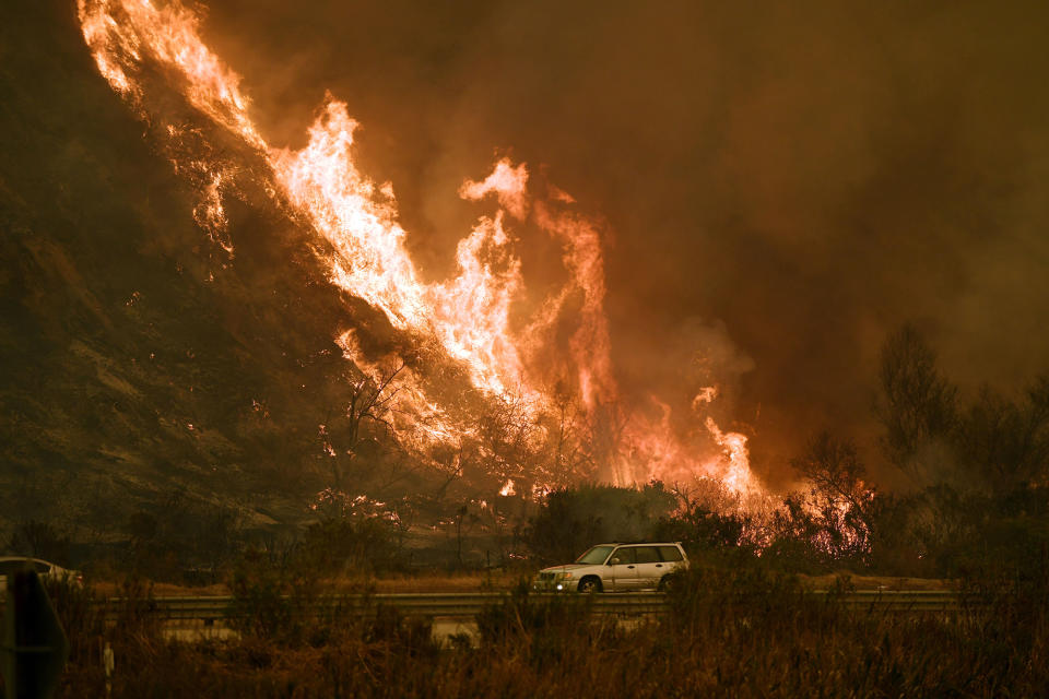 <p>A vehicles passes the Thomas wildfire as it marches toward the 101 highway and the ocean near Ventura, California, on December 6.</p>