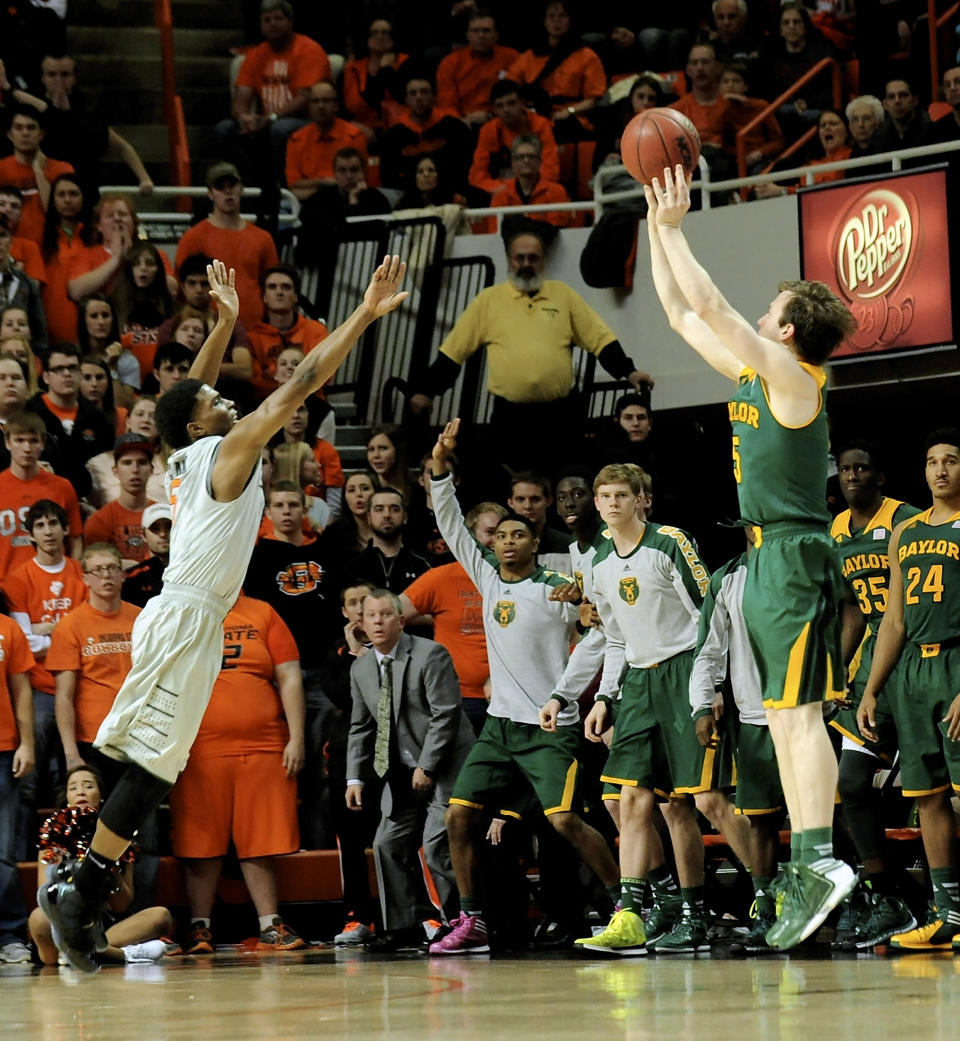 Baylor guard Brady Heslip, right, shoots a 3-point shot over Oklahoma State guard Stevie Clark, left, during the second half of an NCAA college basketball game in Stillwater, Okla., Saturday, Feb. 1, 2014. Heslip scored 20 points in their 76-70 win. (AP Photo/Brody Schmidt)