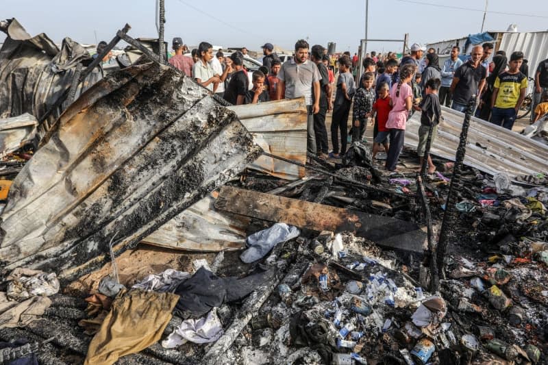 Palestinians inspect their destroyed tents after an Israeli airstrike, which left numerous dead and injured, in the Al-Mawasi area, which was bombarded with a number of rockets targeting the tents of displaced people west of the city of Rafah in southern Gaza Strip.  Abed Rahim Khatib/dpa