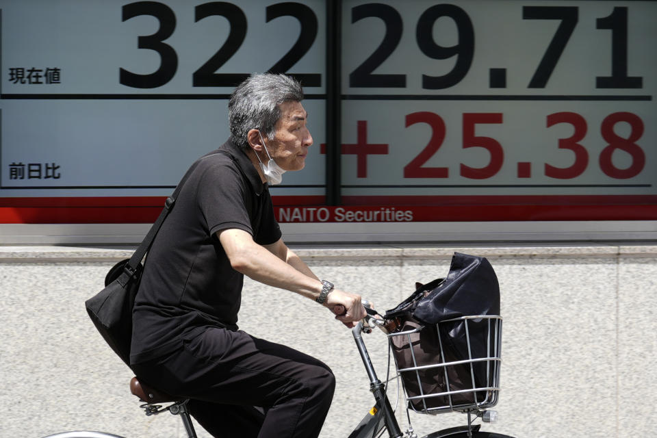 A person rides a bicycle in front of an electronic stock board showing Japan's Nikkei 225 index at a securities firm Thursday, Aug. 10, 2023, in Tokyo. Asian benchmarks mostly fell Thursday after shares declined on Wall Street and investors braced for a highly anticipated report on U.S. inflation. (AP Photo/Eugene Hoshiko)