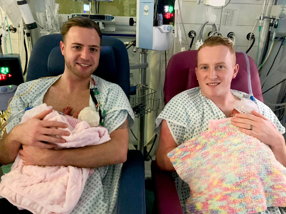 Ryan Morgan, 28, and his fiance Kyran Trodden, 25, hold their identical twin daughters, Skylar and Aria, shortly after their birth. The twins were carried by a surrogate mother. (CATERS NEWS)