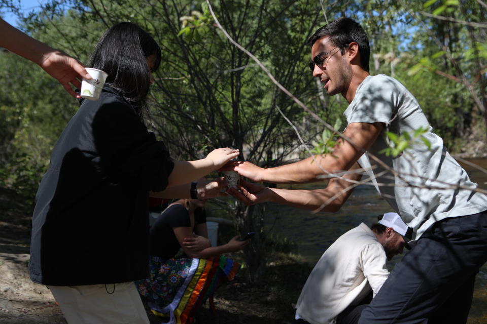 Tyson Marsel, a hatchery biologist for Okanagan Nation Alliance, assists Youth during a salmon ceremonial release hosted by the Okanagan Nation at Mission Creek in syilx Okanagan territory on May 8, 2024. Photo by Aaron Hemens