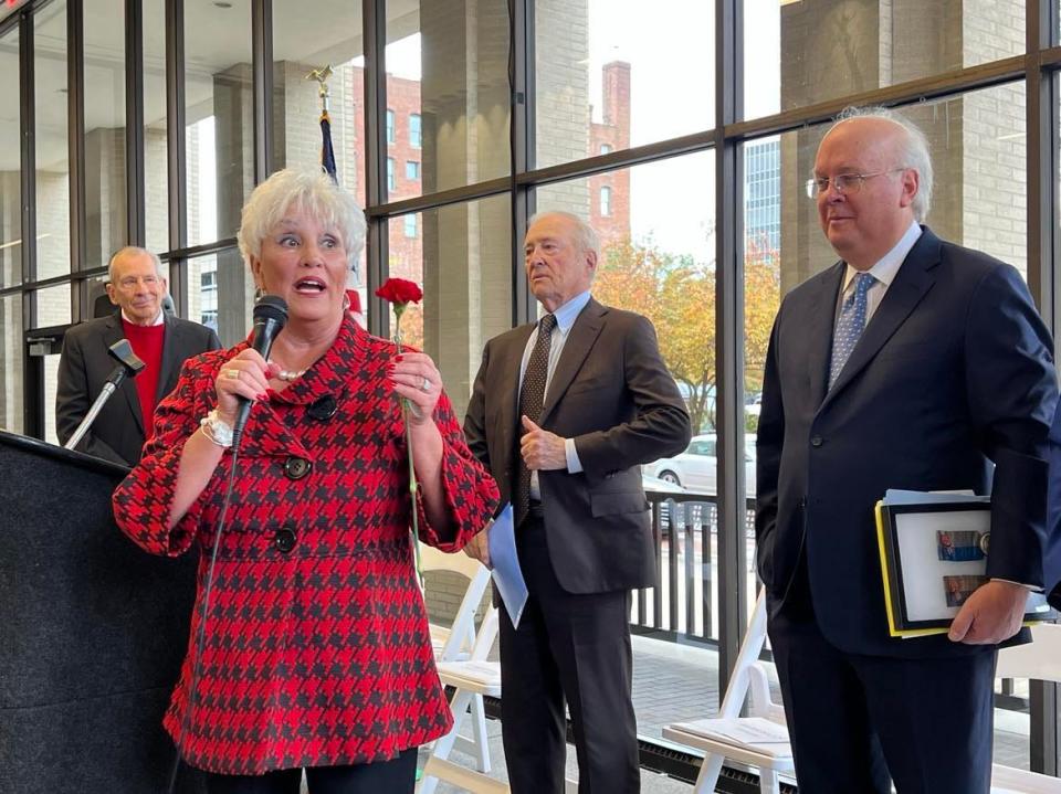 Stark County Commissioner Janet Weir Creighton displays a carnation at a dedication event Saturday for the unveiling of a statue of President William McKinley in Canton. She said McKinley often wore a carnation, Ohio's state flower.