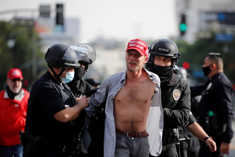 A supporter of U.S. President Donald Trump wearing a Make America Great Again (MAGA) hat reacts upon getting detained by the police while protesting in Los Angeles, California