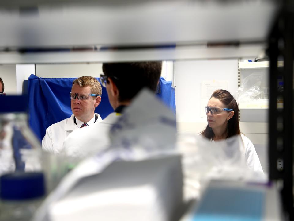 Jacinda Ardern and Covid-19 response minister Chris Hipkins visit a lab at Auckland University after announcing they have secured enough vaccine doses to immunise the whole population (Getty Images)