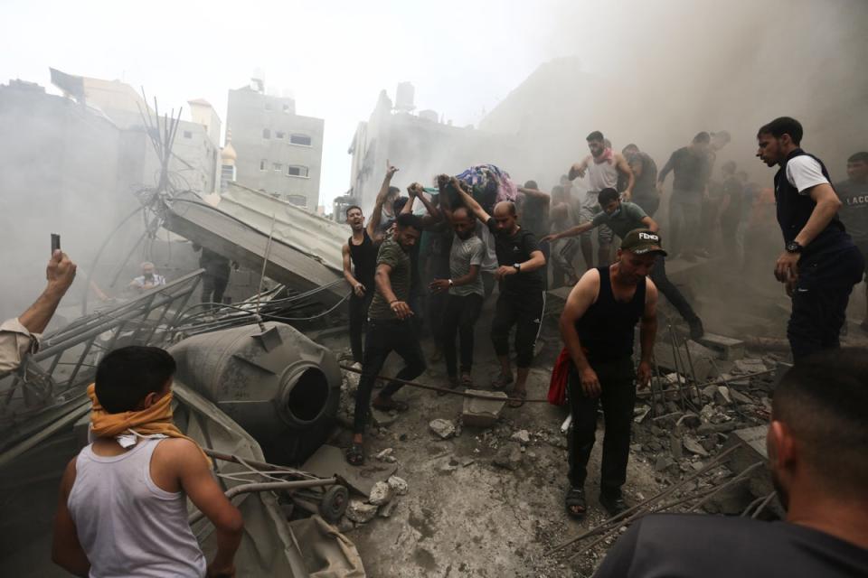 Palestinians remove a dead body from the rubble of a building after an Israeli airstrike Jebaliya refugee camp (AP)